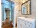 Bathroom featuring tile surround, a vanity with a white sink, and a view into the living room at 1276 Sedeeva N Cir, Clearwater, FL 33755