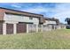 View of the backyard, showcasing a row of townhomes with a well-maintained lawn at 1370 70Th N St # 2-1382, St Petersburg, FL 33710