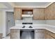 Kitchen featuring white countertops, wooden cabinetry, and an electric range at 1370 70Th N St # 2-1382, St Petersburg, FL 33710