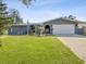 Charming gray single-story home with well-manicured lawn, attractive landscaping, and a two-car garage at 1631 Neva Dr, Largo, FL 33770