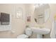 Half bathroom with a pedestal sink, modern toilet, and decorative wall art at 1724 Amberwynd W Cir, Palmetto, FL 34221