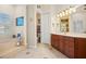 Bright bathroom featuring a soaking tub, wood vanity, tile flooring, and shuttered window at 1724 Amberwynd W Cir, Palmetto, FL 34221