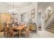 Formal dining room with vintage style table, chairs, and chandelier, adjacent to the staircase at 1724 Amberwynd W Cir, Palmetto, FL 34221