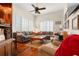 Living room with hardwood floors, large sectional, shuttered windows, and a ceiling fan at 1724 Amberwynd W Cir, Palmetto, FL 34221