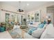 Bright living room with beach accents, comfortable seating, and access to the lanai for indoor-outdoor living at 1724 Amberwynd W Cir, Palmetto, FL 34221