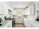 U-shaped kitchen with white cabinets, marble countertops, and modern appliances at 1801 E Mcberry St, Tampa, FL 33610