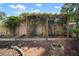 Lush backyard with a vine-covered pergola, brick accent wall, and serene landscaping at 1904 Pepperwood Pl, Brandon, FL 33510