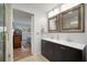 Bathroom with double sink vanity, framed mirrors and a view into an adjacent bedroom at 1904 Pepperwood Pl, Brandon, FL 33510