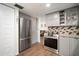 Updated kitchen features stainless steel appliances, gray cabinets, and stylish backsplash at 1904 Pepperwood Pl, Brandon, FL 33510