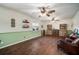 Bright and airy living room with wood look floors, green wainscoting, and shelving at 1904 Pepperwood Pl, Brandon, FL 33510