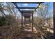 Shaded pergola walkway in a landscaped garden with mature vegetation and privacy wall at 1904 Pepperwood Pl, Brandon, FL 33510