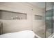 Bright, stylish shower with sleek tile, a glass enclosure, built-in niche and modern fixtures at 1904 Pepperwood Pl, Brandon, FL 33510
