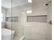 Elegant glass shower with sleek tile, a soaking tub, and modern fixtures in updated bathroom at 1904 Pepperwood Pl, Brandon, FL 33510