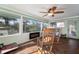Comfortable sunroom featuring a fireplace and rocking chairs with a ceiling fan at 1904 Pepperwood Pl, Brandon, FL 33510