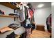 Organized walk-in closet with custom wood shelving and storage for clothes, luggage and accessories at 1904 Pepperwood Pl, Brandon, FL 33510