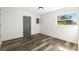 Bedroom featuring modern floors, grey doors, and a view of the landscaped outdoors at 21047 Keeler Ave, Port Charlotte, FL 33954