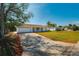 View of the home showing the driveway, 2 car garage, and landscaped front yard on a sunny day at 21047 Keeler Ave, Port Charlotte, FL 33954