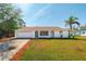 Charming one-story home featuring a well-maintained lawn and a classic, white exterior at 21047 Keeler Ave, Port Charlotte, FL 33954