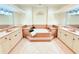 A bright bathroom featuring a standalone tub, dual sinks, decorative lighting and tiled floors at 2329 Como St, Port Charlotte, FL 33948