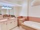 A bright bathroom featuring a standalone tub, single sink, decorative lighting and tiled floors at 2329 Como St, Port Charlotte, FL 33948