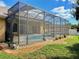 Exterior view of screened pool and patio area surrounded by landscaping at 2329 Como St, Port Charlotte, FL 33948