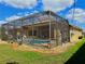 Exterior view of screened-in pool and patio area, with lush yard and landscaping at 2329 Como St, Port Charlotte, FL 33948