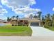 Inviting single Gathering home with tan paint, manicured lawn, and a screened two-car garage at 2329 Como St, Port Charlotte, FL 33948
