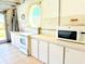 Garage kitchen features classic white cabinets, appliances, and a view to the outside at 2329 Como St, Port Charlotte, FL 33948