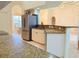 Bright kitchen featuring stainless refrigerator, granite counters, and a breakfast bar at 2329 Como St, Port Charlotte, FL 33948