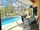 Relaxing screened-in pool area with an outdoor dining set, perfect for entertaining or enjoying quiet moments at 2329 Como St, Port Charlotte, FL 33948