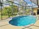Inviting screened-in pool with water features, tile surround, and lush landscaping at 2329 Como St, Port Charlotte, FL 33948