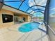 Inviting backyard pool with screened enclosure, outdoor dining, and water features at 2329 Como St, Port Charlotte, FL 33948