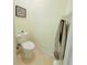 A toilet in a bathroom featuring neutral walls, tiled floors and a towel hanger at 2329 Como St, Port Charlotte, FL 33948
