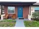 Inviting brick front porch featuring a blue door, two wooden chairs, and a small table at 24862 Us Highway 19 N # 3001, Clearwater, FL 33763