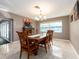 Bright dining room featuring a traditional wood table, stylish lighting, and neutral walls at 2671 Clubhouse N Dr, Clearwater, FL 33761