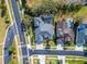 An aerial view of a home with a private screened pool, mature landscaping, and three car garage at 2903 Marble Crest Dr, Land O Lakes, FL 34638