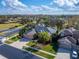 Aerial view of a home with a green lawn, mature trees, and a three car garage at 2903 Marble Crest Dr, Land O Lakes, FL 34638