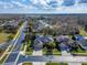 An aerial view of a home with a well-maintained lawn, mature trees, and a three car garage at 2903 Marble Crest Dr, Land O Lakes, FL 34638