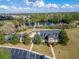 Drone photo of the community clubhouse with lake view, pool and lounge chairs, lush trees, and parking area at 2903 Marble Crest Dr, Land O Lakes, FL 34638