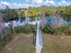 A wooden dock extends into the lake with trees and cloudy skies in the background at 2903 Marble Crest Dr, Land O Lakes, FL 34638