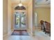Inviting entryway featuring double glass doors, transom window, ceramic tile floor, and decorative rug at 2903 Marble Crest Dr, Land O Lakes, FL 34638