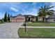 Charming home with a three-car garage, lush landscaping, and a brick-paved driveway at 2903 Marble Crest Dr, Land O Lakes, FL 34638