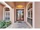 Elegant front entrance with double doors, arched windows, and lush landscaping at 2903 Marble Crest Dr, Land O Lakes, FL 34638