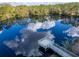 An aerial view of a lake shows a wooden dock and reflections of the sky at 2903 Marble Crest Dr, Land O Lakes, FL 34638