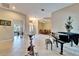 Open living room with tile floors and grand piano that leads to the dining room at 2903 Marble Crest Dr, Land O Lakes, FL 34638
