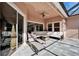 A covered patio offers an inviting outdoor seating area, featuring a plush sofa and lounge chairs and ceiling fan at 2903 Marble Crest Dr, Land O Lakes, FL 34638
