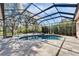 Private screened-in pool and spa with paved patio are surrounded by green landscaping at 2903 Marble Crest Dr, Land O Lakes, FL 34638