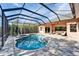 A screened-in pool and spa are accompanied by outdoor seating on a paved patio at 2903 Marble Crest Dr, Land O Lakes, FL 34638