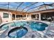 An inviting screened-in pool with a built-in spa and outdoor seating on a paved patio at 2903 Marble Crest Dr, Land O Lakes, FL 34638