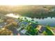A beautiful aerial view of homes lining a pond with mature trees and landscaping at 3339 Brenford Pl, Land O Lakes, FL 34638